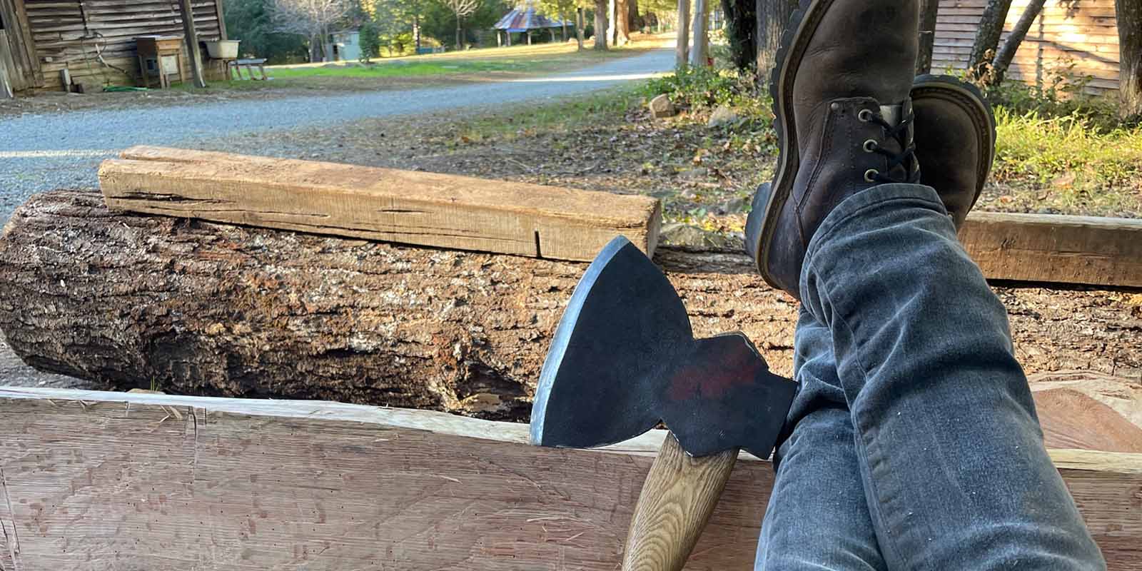 axe and legs propped up against a log